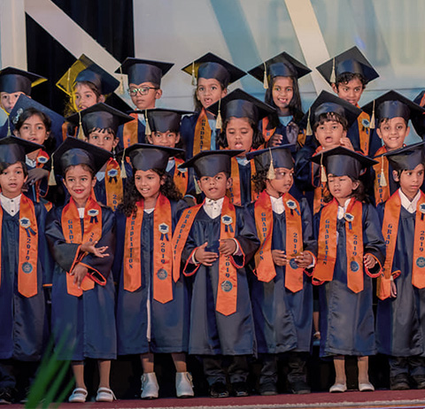 Brightway International School Students standing in a group after their graduation ceremony wearing robes and hats