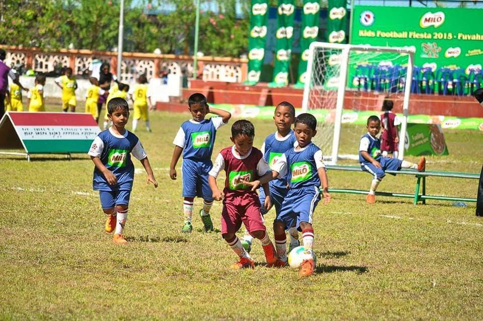 Children playing football in a field
