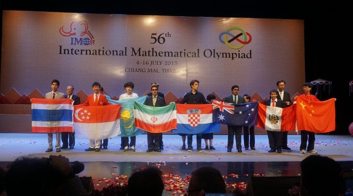 students from different countries holding their country flag standing on a stage